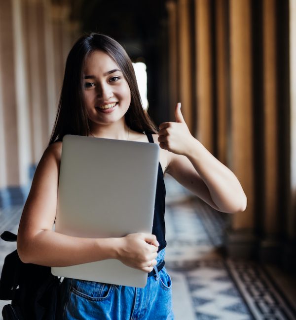 Portrait of young Asian woman student using a laptop or tablet in smart and happy pose at university or college