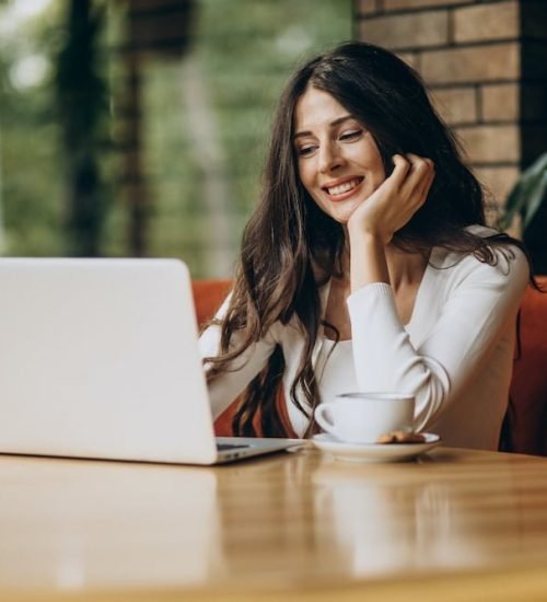 Young beautiful business woman working on cimputer in a cafe